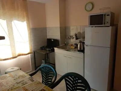 a small kitchen with a refrigerator and a microwave at Лятна вила Генчеви град Обзор in Obzor