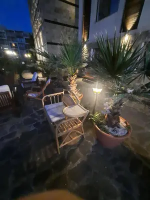 a patio with chairs and potted plants at night at Апатаменти за гости Sunshine и Glory in Sveti Vlas