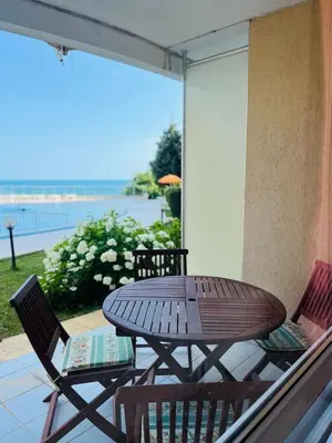 a table and chairs on a balcony with a view of the ocean at Seafront apartment Lucky in Sveti Vlas
