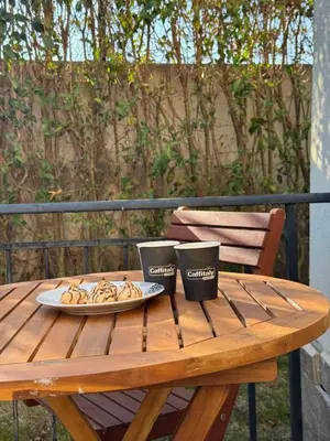a wooden table with two cups and a plate of food at Marteo Apartments103 - Sozopol in Sozopol