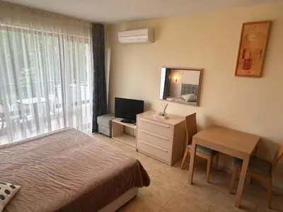 a bedroom with a bed and a desk and a television at River Park Studio in Sunny Beach