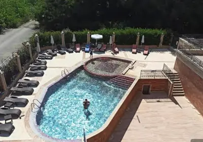 a pool at a resort with chairs and a person in it at River Park Studio in Sunny Beach