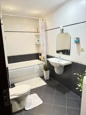 a bathroom with a toilet and a sink and a tub at Stan u moru in Pomorie