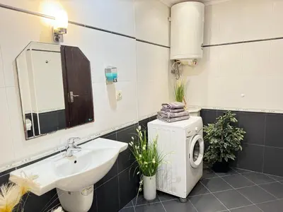 a bathroom with a sink and a washing machine at Stan u moru in Pomorie