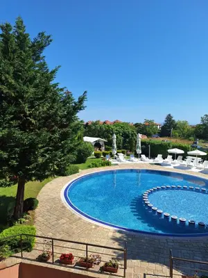 a large swimming pool with chairs and a tree at Созополи Хилс A11 in Sozopol
