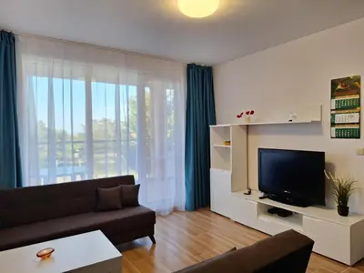 a living room with a couch and a television at Созополи Хилс A11 in Sozopol