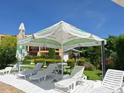 a group of white chairs and a white umbrella at Созополи Хилс A11 in Sozopol