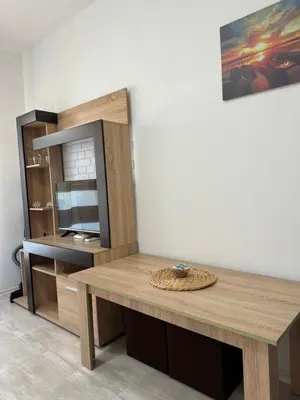 a room with a wooden table and a tv at Marteo Apartments 105 - Sozopol in Sozopol