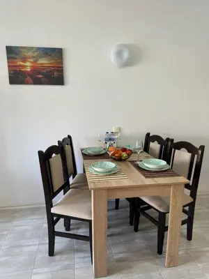 a wooden table with chairs and a bowl of fruit on it at Marteo Apartments 105 - Sozopol in Sozopol