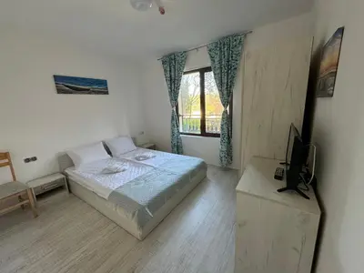 a bedroom with a bed and a television in it at Marteo Apartments 105 - Sozopol in Sozopol