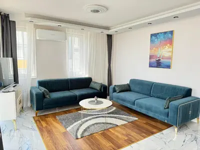 a living room with two blue couches and a table at Boutique Sozopol in Sozopol