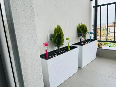 a row of planters on a balcony with plants at Boutique Sozopol in Sozopol