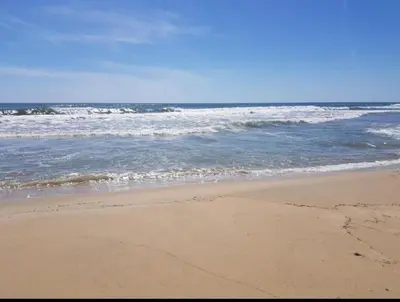 a sandy beach with waves in the ocean at Brymonte Studio, Sunny Day 6 in Tŭnkovo