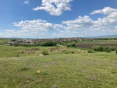 a field of grass with a town in the background at Brymonte Studio, Sunny Day 6 in Tŭnkovo