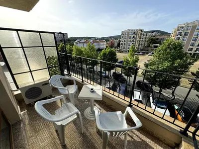 a balcony with chairs and tables and a view of a parking lot at Sea view Prestige Fort beach Apartment in Sveti Vlas
