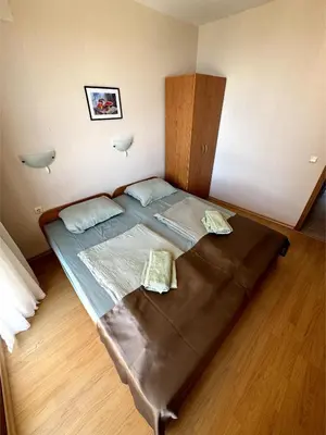 a large bed in a room with a wooden floor at Sea view Prestige Fort beach Apartment in Sveti Vlas
