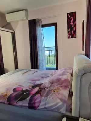 a bedroom with a bed with a flower blanket at Луксозен апартамент в Резиденция Лазурен бряг in Burgas City