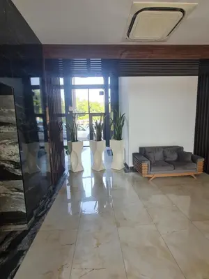a living room with a couch and some plants at Луксозен апартамент в Резиденция Лазурен бряг in Burgas City