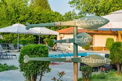 a sign in front of a swimming pool at Хотел и Вили Марая apartament in Tsarevo