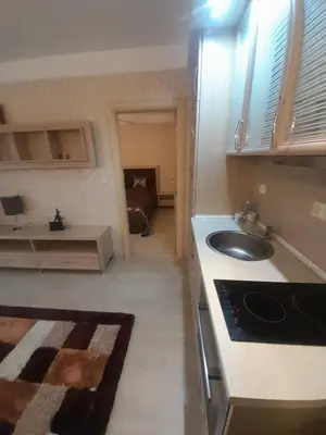 a small kitchen with a sink and a living room at 2 Room Apartment Harmony Suites Komplex in Sunny Beach