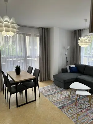 a living room with a couch and a table and chairs at Cascadas family apartamant 2 in Sunny Beach
