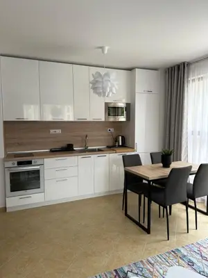 a kitchen with white cabinets and a table and chairs at Cascadas family apartamant 2 in Sunny Beach