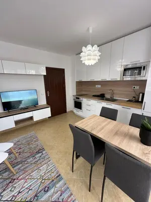 a kitchen with a table and chairs and a television at Cascadas family apartamant 2 in Sunny Beach