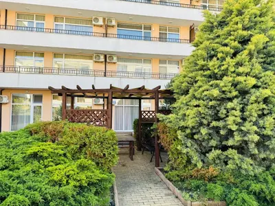 an outside view of a building with a patio with a bench at GRAND KAMELIA B 2,8 Large Studio Sunny Beach in Sunny Beach