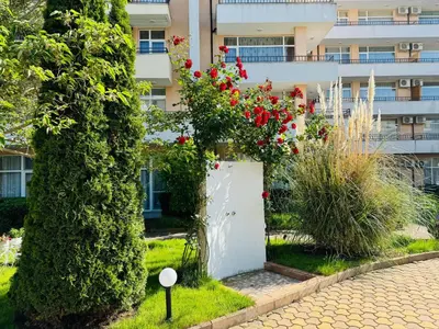 a white gate with flowers in front of a building at GRAND KAMELIA B 2,8 Large Studio Sunny Beach in Sunny Beach
