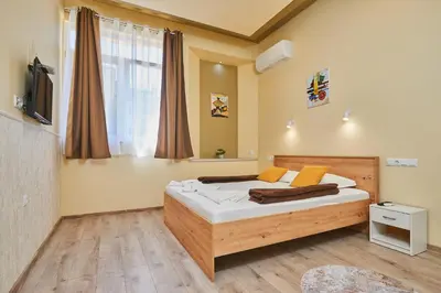 a bedroom with a bed and a television in a room at Апартамент Пенека in Pomorie