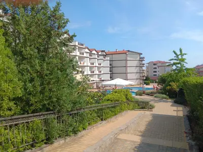 a walkway next to a pool with a building at Royal Palm Studio, Sveti Vlas in Sveti Vlas