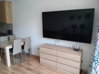 a living room with a large flat screen tv on a wall at Royal Palm Studio, Sveti Vlas in Sveti Vlas
