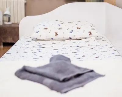 a white bed with a pile of clothes on it at Premium Lazur - Sea garden Burgas - TOP Location 5 min to the Beach in Burgas City