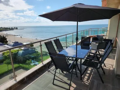 a table and chairs on a balcony with a view of the beach at APART SUNNY BAY a SUNNY BEACH in Sunny Beach