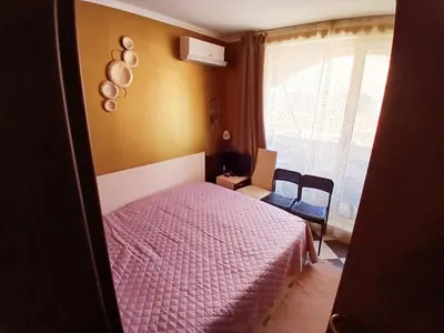 a bedroom with a pink bed and a window at Golden Hacienda in Sozopol