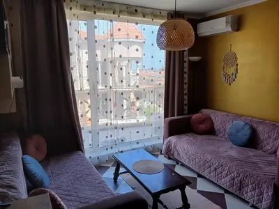 a living room with two couches and a large window at Golden Hacienda in Sozopol