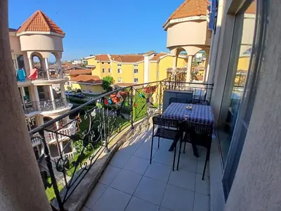 a balcony with a table and a view of a city at Golden Hacienda in Sozopol