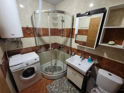 a bathroom with a shower and a toilet and a sink at Prestige Fort Beach apartment in Sveti Vlas