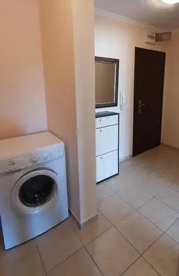 a laundry room with a washing machine and a tv at Sunny Day Pomorie in Pomorie