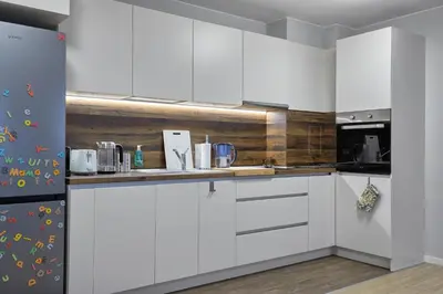 a kitchen with white cabinets and a refrigerator at The little things apt - Parking & Own EV Chаrgеr by Flat Mаnаger in Burgas City