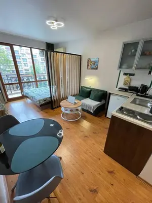 a kitchen and living room with a table and a couch at GreenStudio w Sveti Vlas in Sveti Vlas