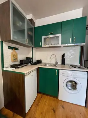 a kitchen with green cabinets and a washing machine at GreenStudio w Sveti Vlas in Sveti Vlas