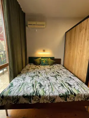 a bedroom with a large bed with a large headboard at GreenStudio w Sveti Vlas in Sveti Vlas