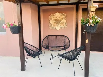 a patio with three chairs and a table and a door at Saint Anastasia lozenets in Lozenets