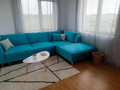 a blue couch in a living room with a table at Bulgapart Obzor in Obzor