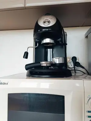 a black coffee maker sitting on top of a microwave at Bulgapart Obzor in Obzor