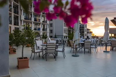 a patio with chairs and tables and umbrellas at The Cliff Hotel and Holiday Apartments by Flat Mаnаger in Obzor