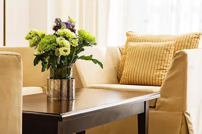 a vase of flowers on a table on a couch at The Cliff Hotel and Holiday Apartments by Flat Mаnаger in Obzor
