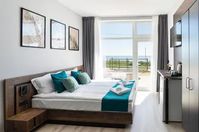 a bedroom with a bed and a large window at Paradise View Rooms in Shkorpilovtsi