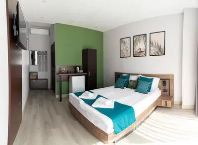 a bedroom with a large bed with blue and green walls at Paradise View Rooms in Shkorpilovtsi